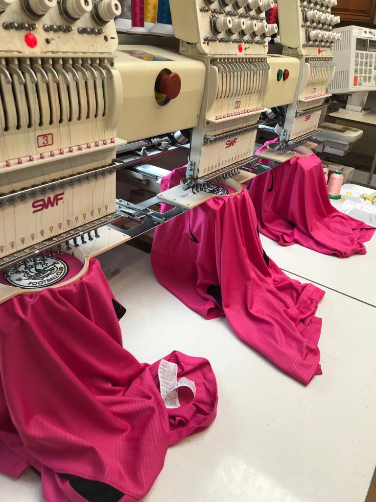 Multi-head embroidery machines at the WearYourLogo workshop